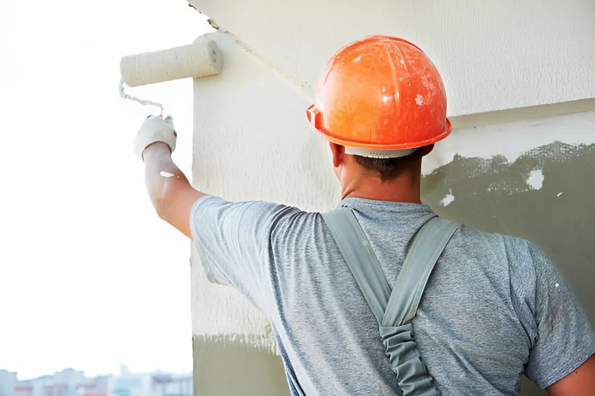 Hiring Professional painter busy with exterior paint application