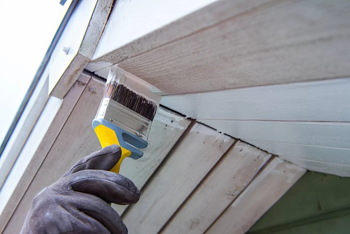 Professional painter applying a paint finish on a home exterior