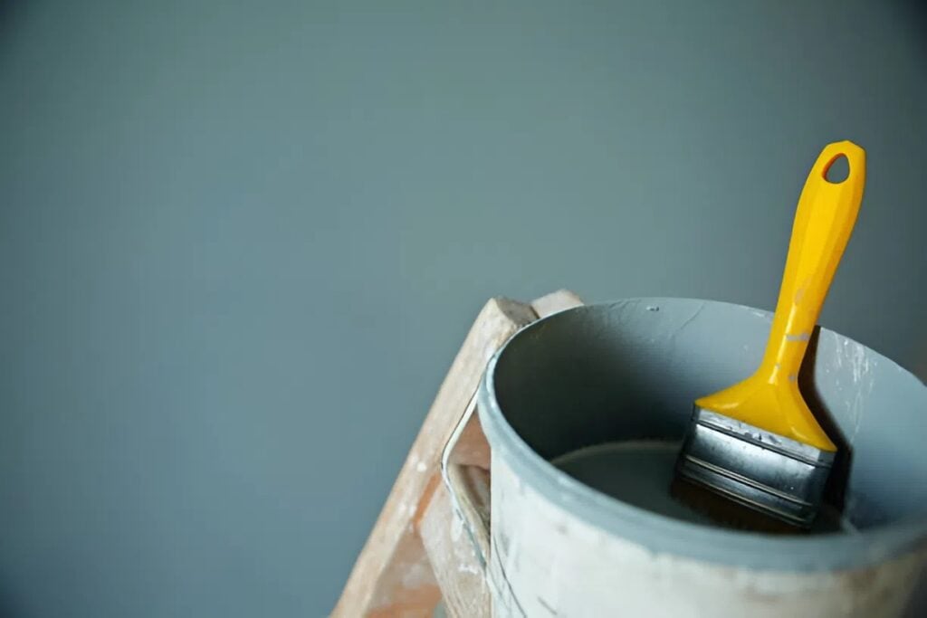 Paint bucket and brush used by a painter in St. Cloud & Maple Grove, MN, during an interior painting project