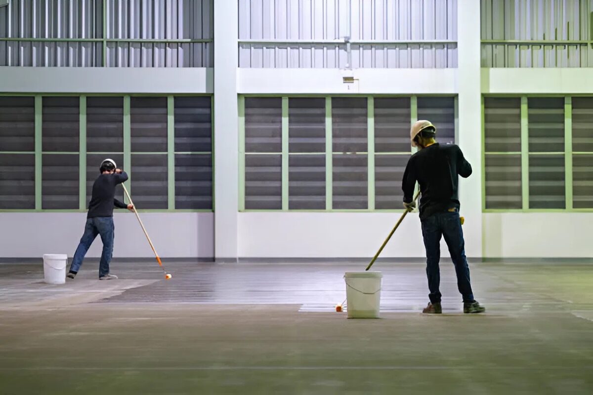 Commercial painters applying durable floor coating in a warehouse facility by a painter in Andover, MN