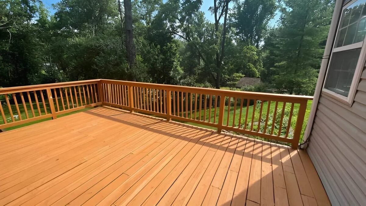 Freshly refinished wooden backyard deck with smooth stain finish and clean railings by a house painter in Monticello, MN