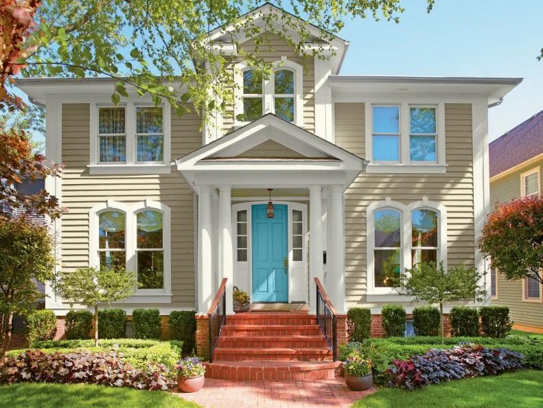 Fresh beige exterior house paint with white trim and blue entry door by an exterior painter in Sartell, MN