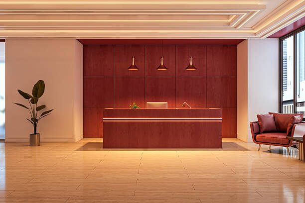 Modern office reception with rich red wood tones and warm interior palette by an interior painter in Maple Grove, MN