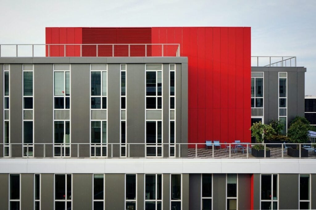 Modern commercial building with bold red and gray exterior design by a painting company in Andover, MN