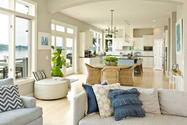 Living room and kitchen with soft beige walls, crisp white trim, and satin finish by a house painter in Champlin, MN.