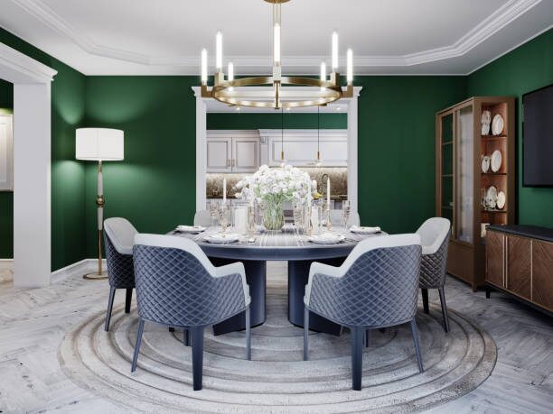 Dining room with deep green painted walls, crisp white trim, and crown molding by a painting company in Edina, MN.